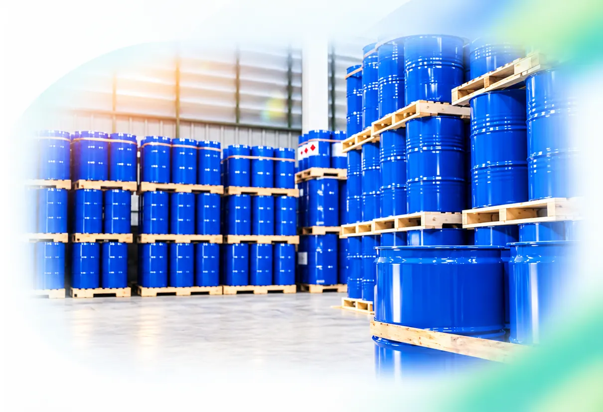 Blue chemical drums stacked on pallets in a warehouse