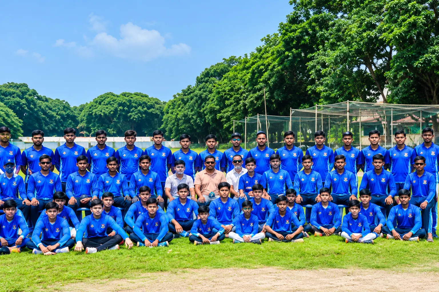 Young cricketers of the Cricket Academy of Mymensingh in blue kit, posing as a team on the field